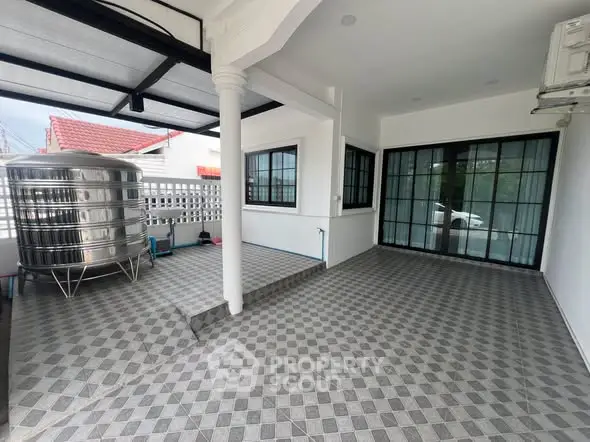 Spacious tiled balcony with modern water tank and sliding glass doors