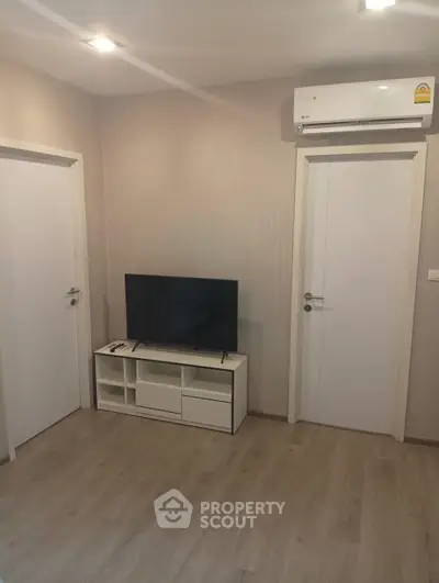 Modern living room with sleek TV setup and air conditioning, perfect for cozy entertainment.