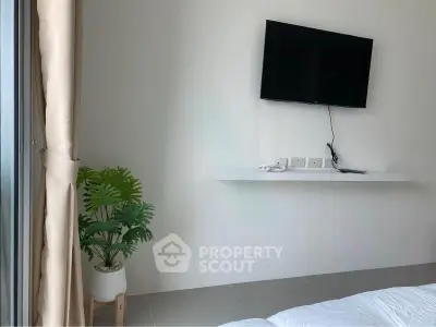 Modern bedroom with wall-mounted TV and minimalist decor