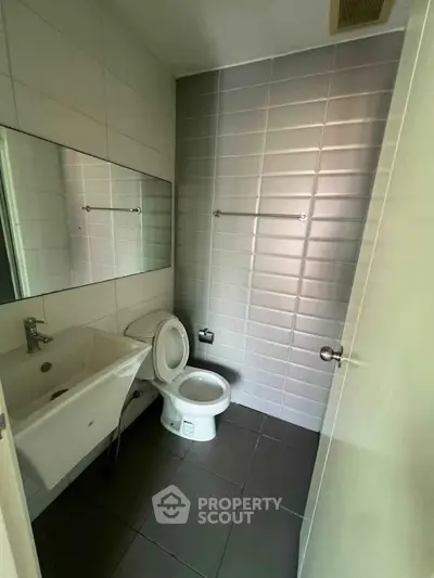 Modern bathroom with sleek tiles and contemporary fixtures in a stylish real estate property.