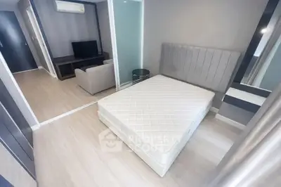 Modern bedroom with sleek design and cozy living area in a stylish apartment.