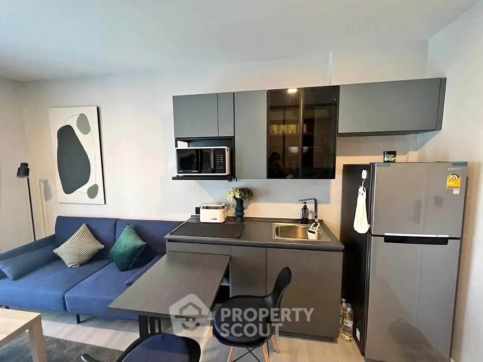 Modern compact kitchen with sleek cabinetry and integrated appliances in a stylish apartment.