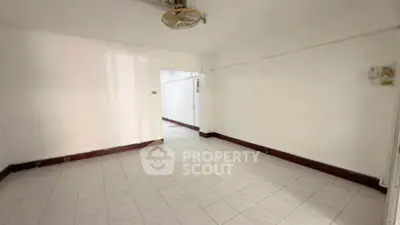 Spacious empty room with tiled flooring and white walls, ideal for customization.