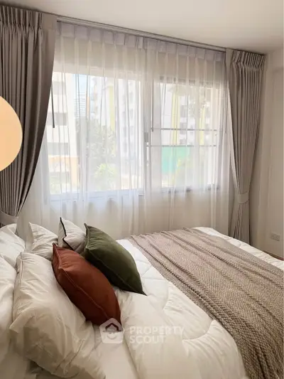Bright and cozy bedroom with large windows and elegant curtains in a modern apartment.