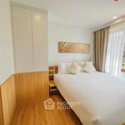 Modern bedroom with elegant decor and natural light, featuring a cozy bed and stylish wooden accents.