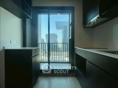 Modern kitchen with sleek cabinetry and balcony view in urban apartment