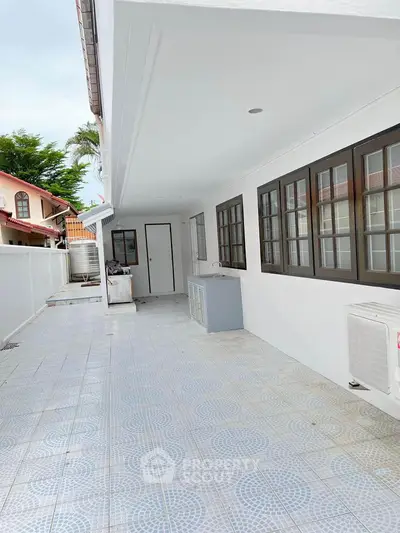 Spacious outdoor patio area with tiled flooring and modern design