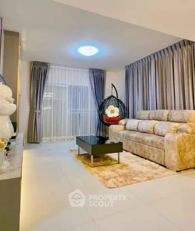 Elegant living room with plush sofa, modern decor, and cozy hanging chair for ultimate relaxation.