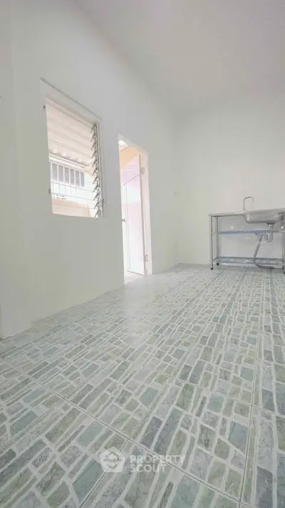 Spacious kitchen with modern tiled flooring and stainless steel sink, perfect for culinary enthusiasts.