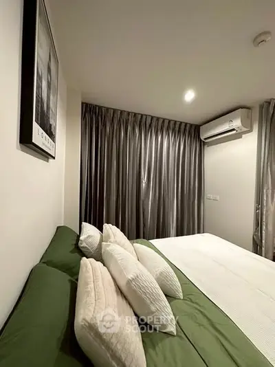 Cozy bedroom with modern decor and air conditioning, featuring elegant curtains and stylish bedding.