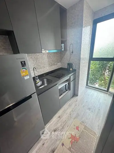 Modern compact kitchen with sleek appliances and large window view