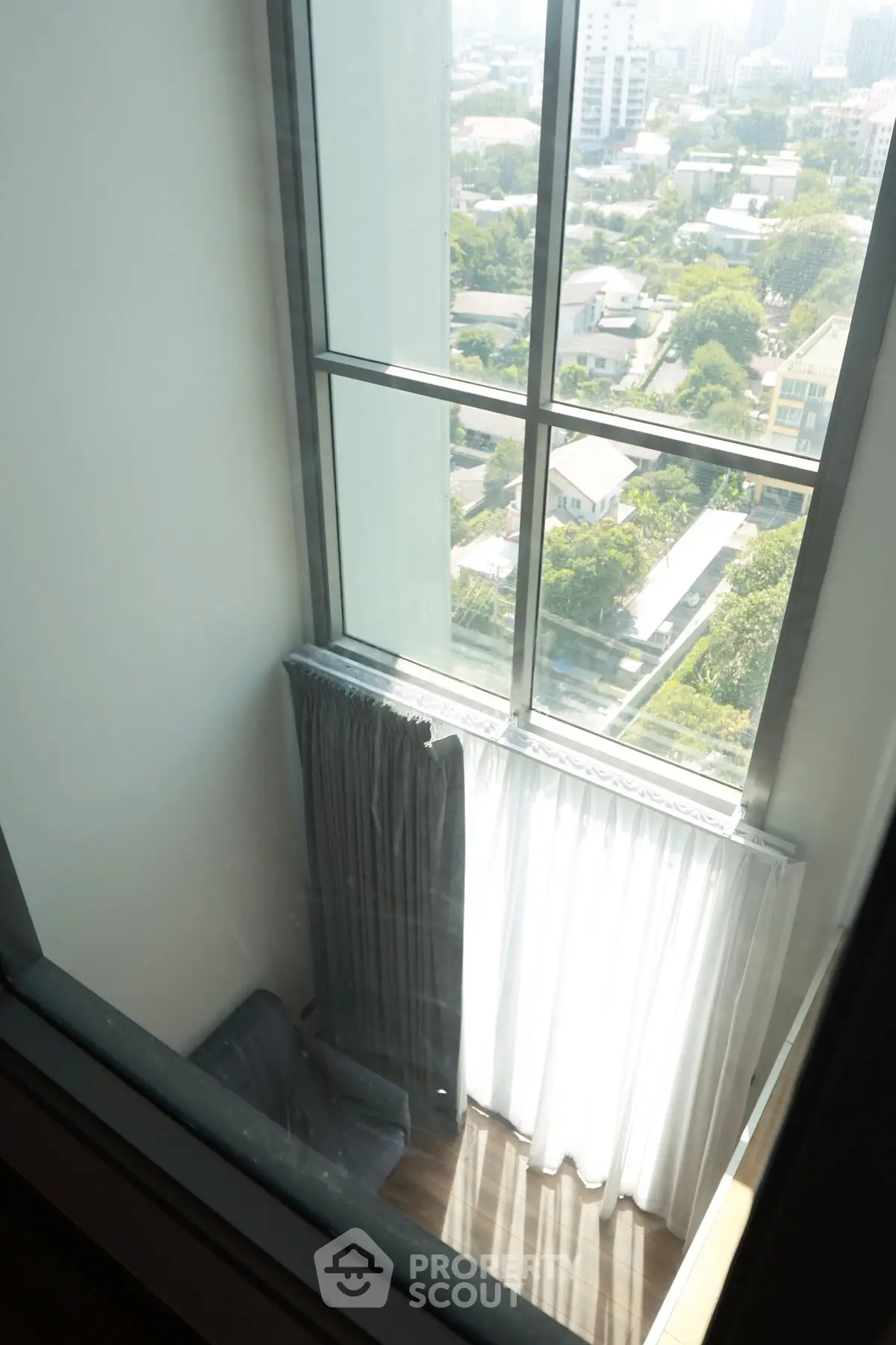 Stunning high-rise view from a modern apartment with floor-to-ceiling windows.