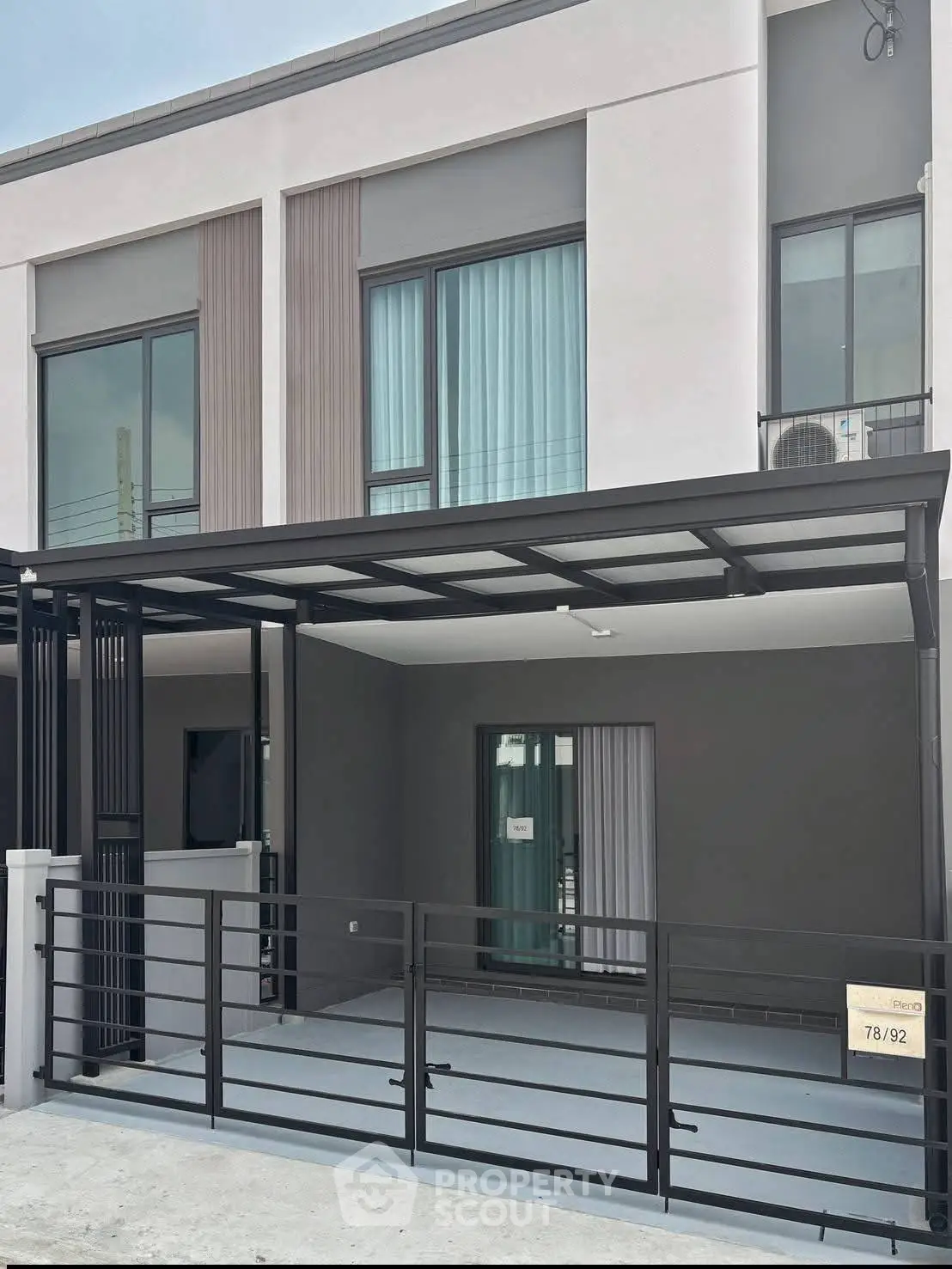 Modern townhouse exterior with sleek design and spacious carport, perfect for urban living.