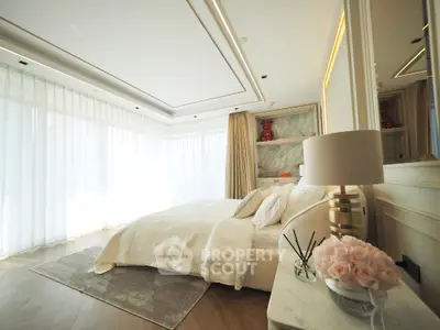 Luxurious bedroom with elegant decor and large windows offering abundant natural light.