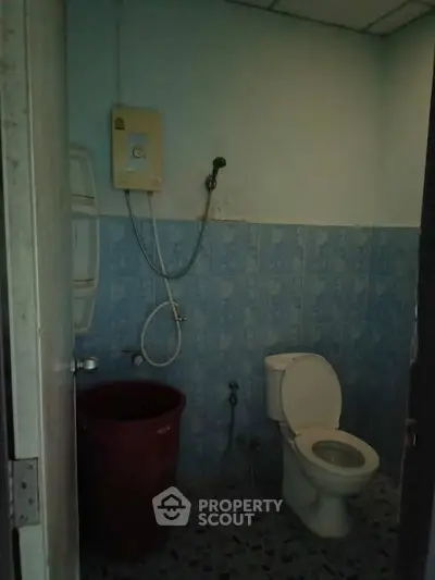 Cozy bathroom with shower and toilet, featuring blue tiled walls and practical layout.