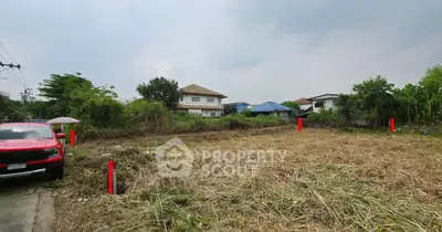 Vacant land plot with nearby houses, ideal for development in a residential area.