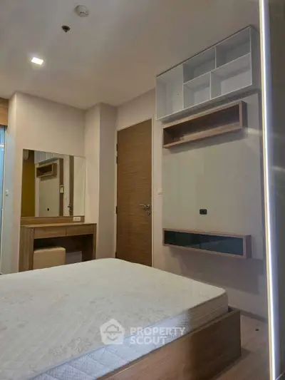 Modern bedroom with built-in storage and vanity, featuring sleek design and neutral tones.