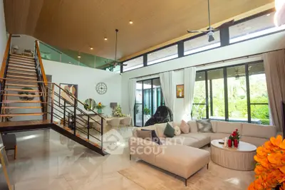 Luxurious open-plan living room with modern staircase and garden view.