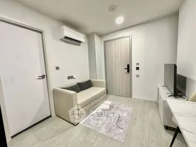 Modern living room with sleek design, featuring a cozy sofa, air conditioning, and a flat-screen TV.