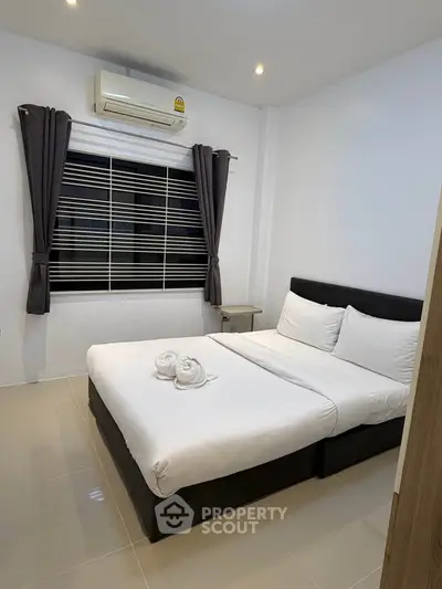 Modern bedroom with sleek design, featuring a comfortable bed and air conditioning for ultimate relaxation.