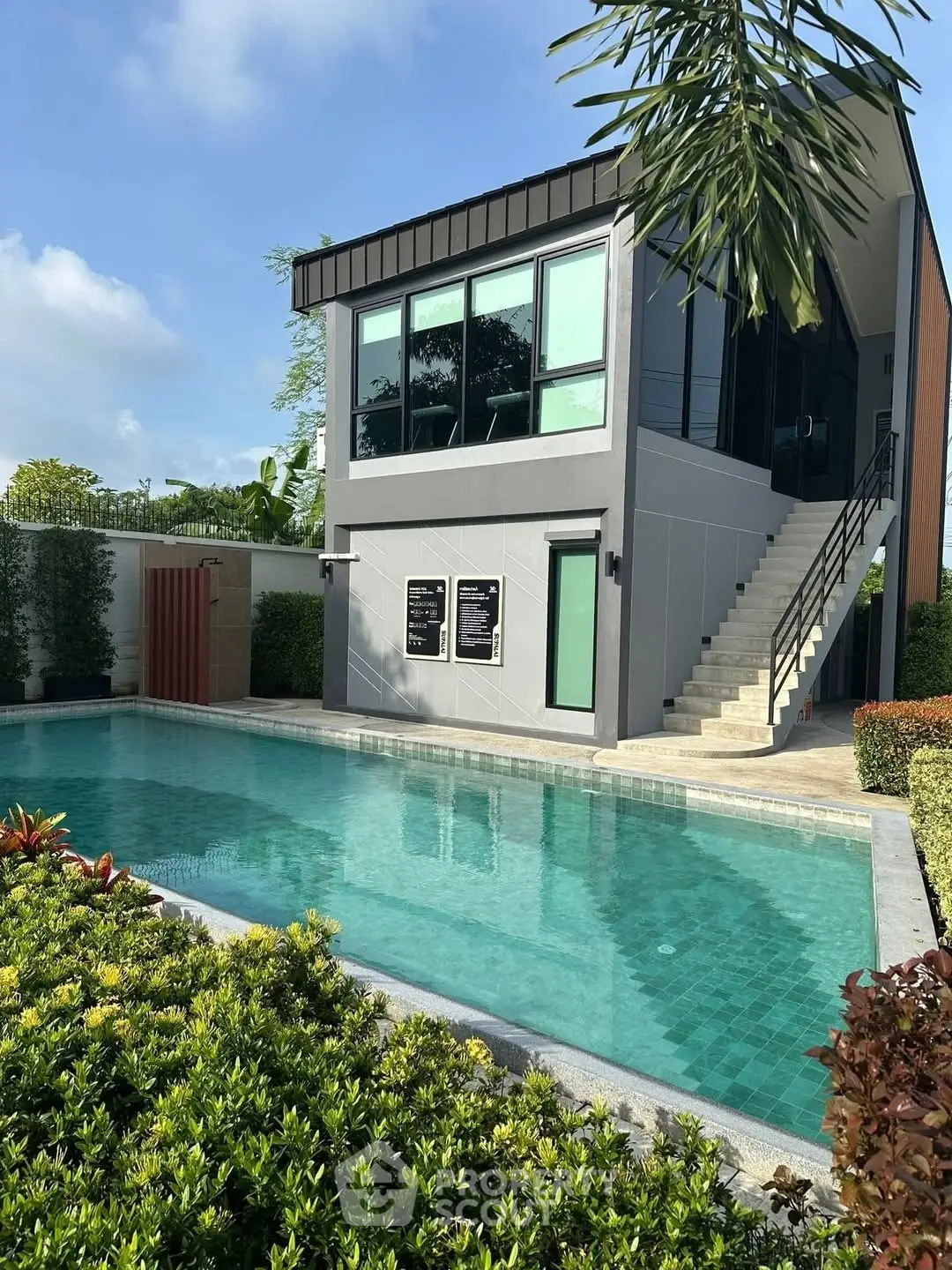 Modern building with pool and lush greenery, perfect for luxury living.