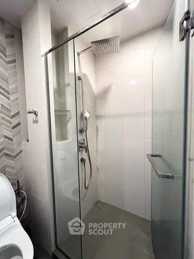 Modern bathroom with glass shower enclosure and sleek fixtures