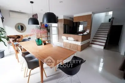 Modern open-plan kitchen and dining area with sleek design and stylish furniture.