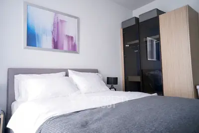 Modern bedroom with stylish decor and cozy bedding in a contemporary apartment.