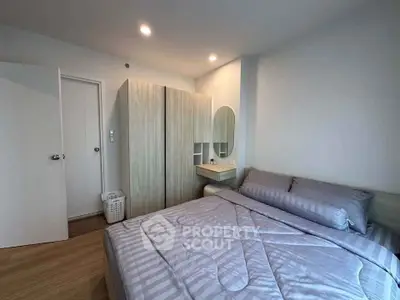 Modern bedroom with stylish decor and ample storage space in a cozy apartment.