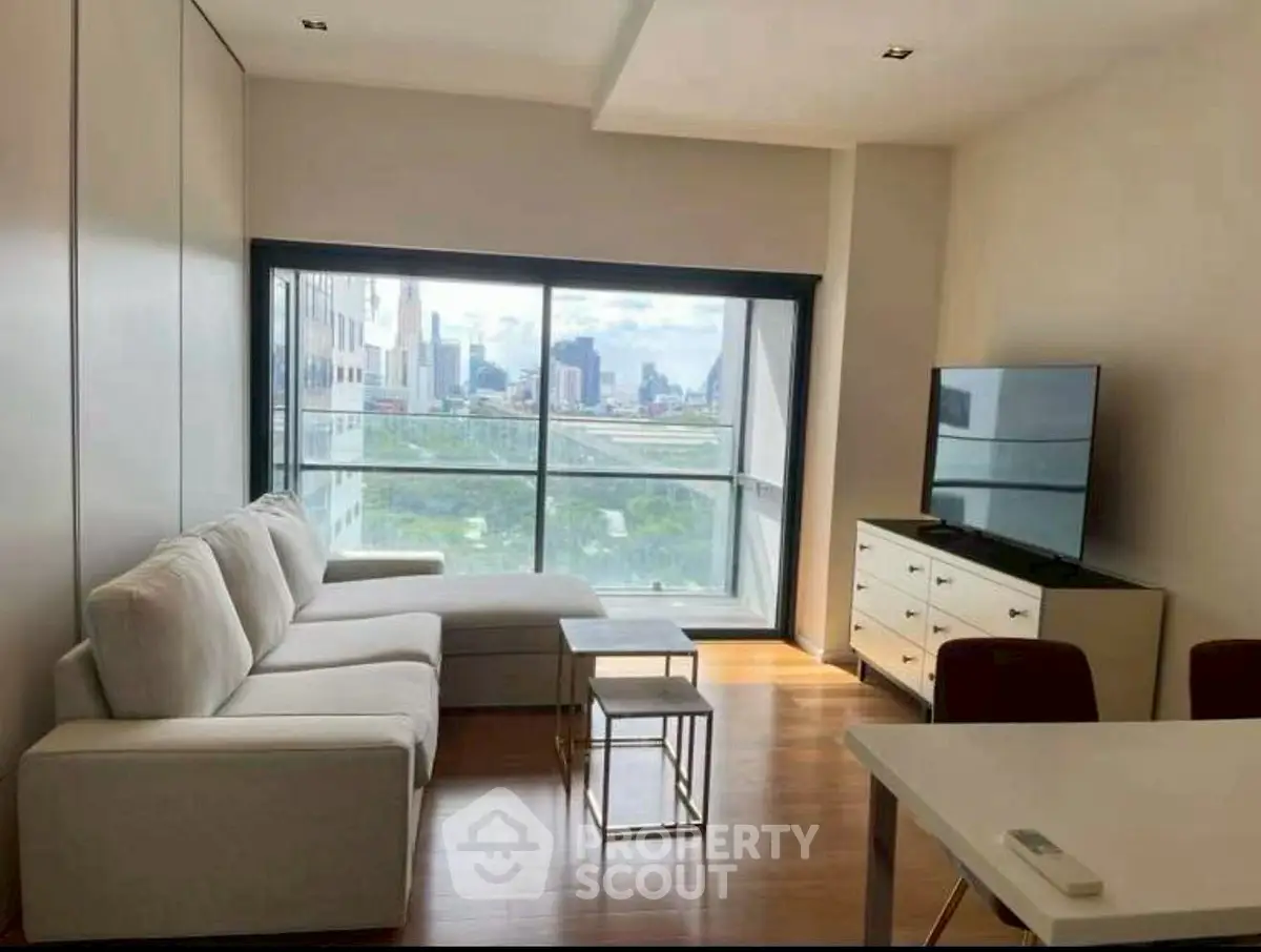 Modern living room with city view, sleek furniture, and large window for natural light.