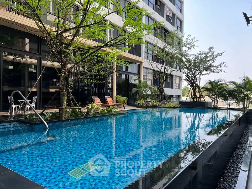 Luxurious apartment building with stunning outdoor pool and lush greenery, perfect for relaxation and leisure.
