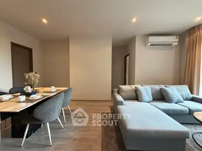 Modern living room with stylish furniture and dining area, featuring a cozy sectional sofa and elegant dining set.