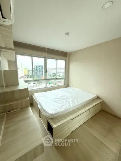 Modern bedroom with large windows and city view, featuring built-in storage and minimalist design.