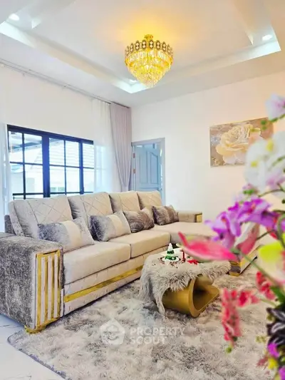 Luxurious living room with plush sofa, elegant chandelier, and stylish decor for a sophisticated ambiance.