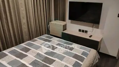 Modern bedroom with stylish decor and wall-mounted TV, perfect for relaxation.