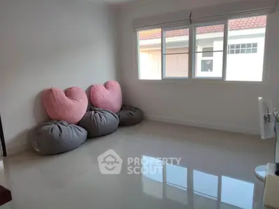 Spacious room with heart-shaped bean bags and large window offering natural light.