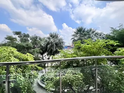 Stunning balcony view with lush greenery and clear blue sky.