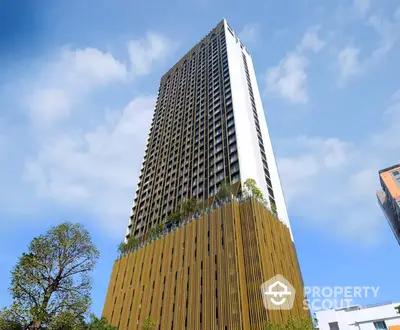 Stunning high-rise building with modern architectural design and lush greenery at the base.