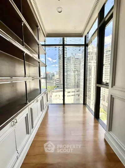 Luxurious study room with floor-to-ceiling windows and built-in shelves offering stunning city views.