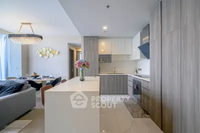 Modern open-plan kitchen and living room with elegant decor and natural light.