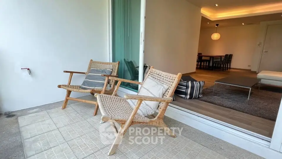 Charming balcony with cozy seating and view into modern living room