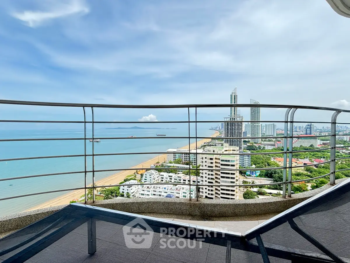 Stunning high-rise balcony view overlooking ocean and city skyline, perfect for luxury living.