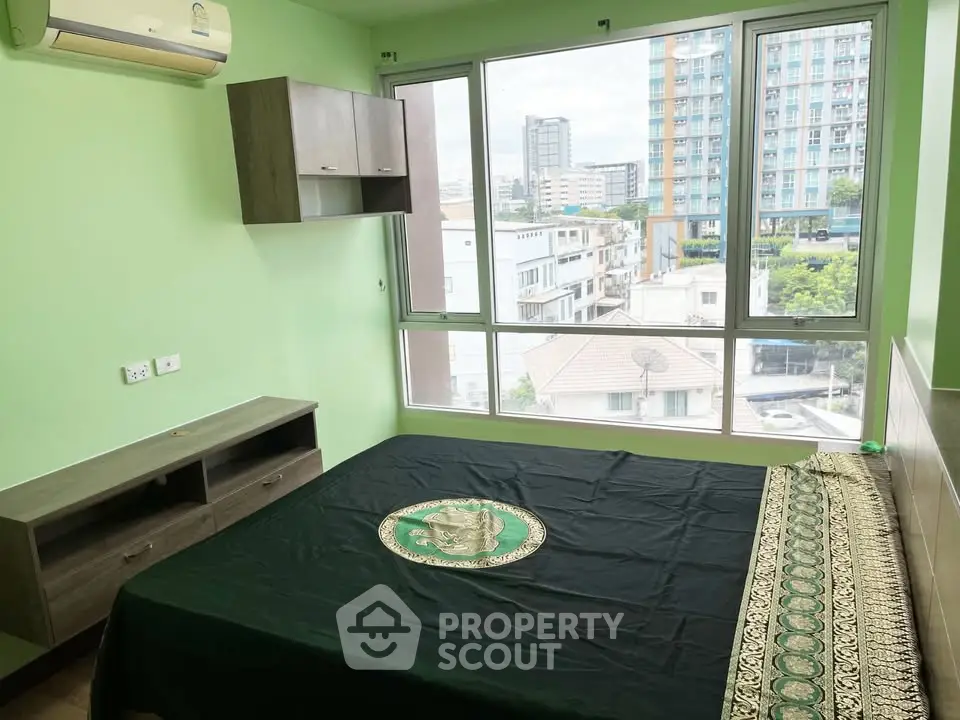 Spacious bedroom with large windows offering city views in modern apartment