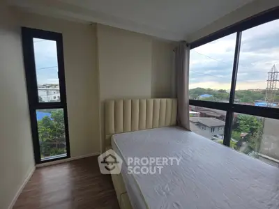 Bright bedroom with large windows offering a stunning view, featuring a modern bed and elegant flooring.