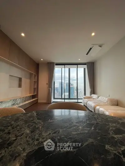 Spacious modern living room with city view, elegant marble table, and cozy seating area.