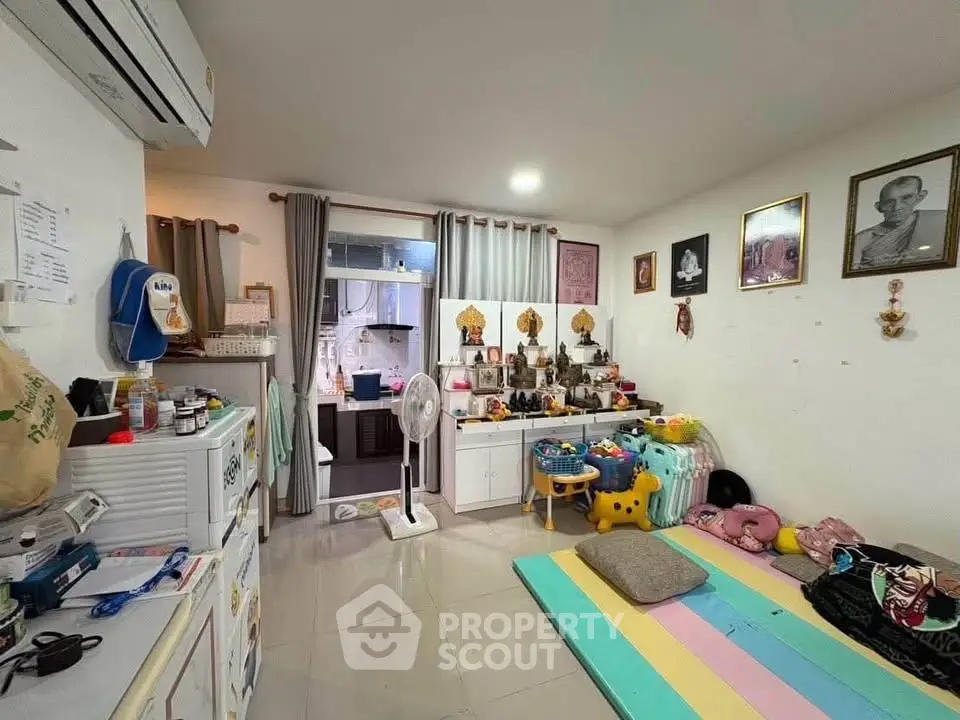 Cozy living room with colorful play area and modern kitchen in open layout apartment.
