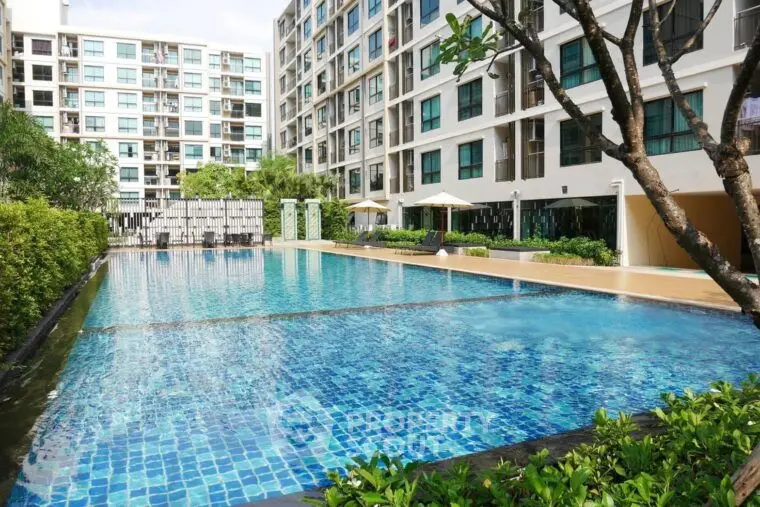 Luxurious condominium with sparkling pool and modern architecture, perfect for urban living.