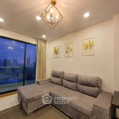 Modern living room with stylish gray sectional sofa and city view through large window.