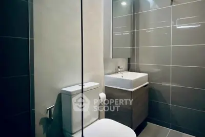 Modern bathroom with sleek tiles and contemporary fixtures in a stylish apartment.