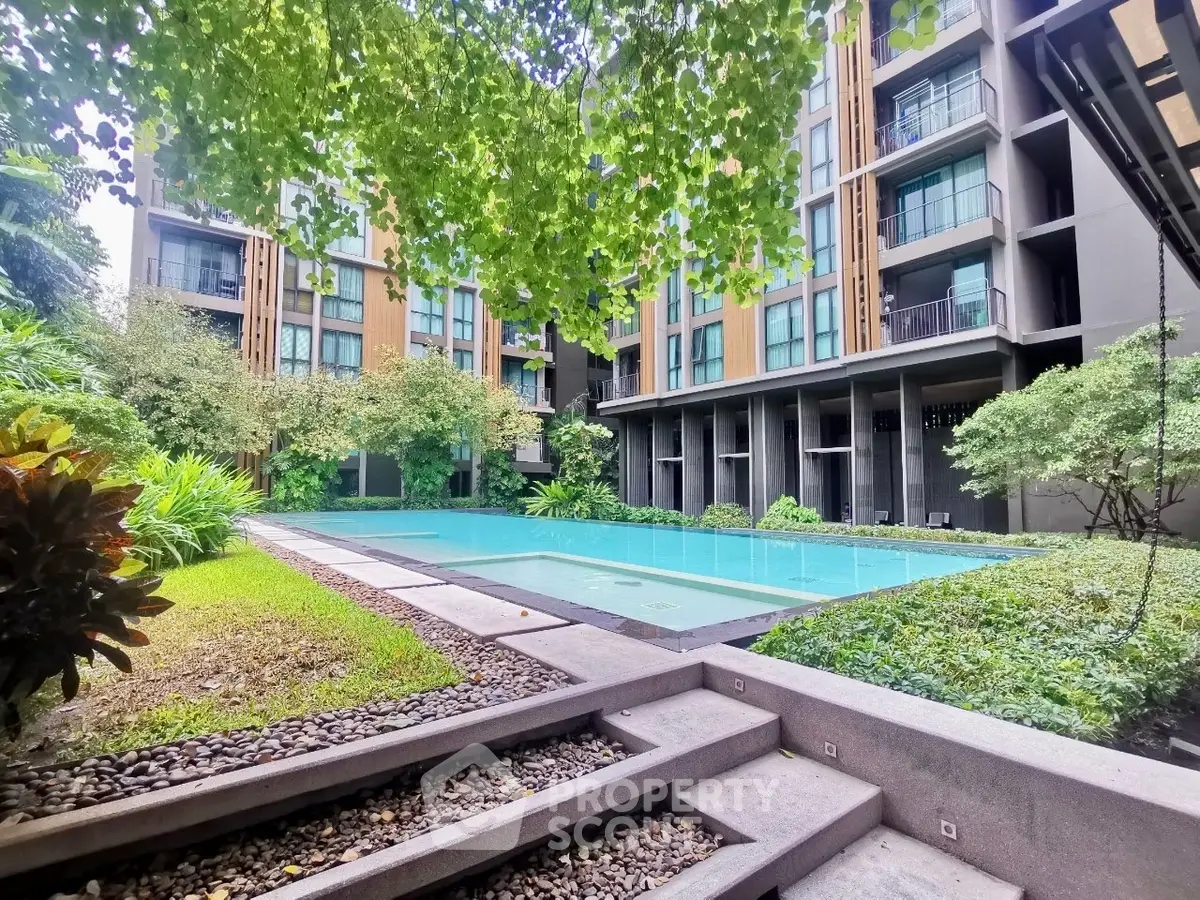 Luxurious condominium with serene pool and lush garden view